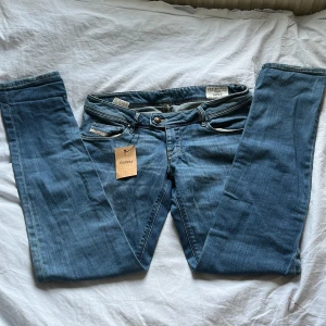Blå jeansbyxor från diesel - Säljer ett par klassiska blå jeans från diesel med normal passform och raka/skinny ben. Byxorna har fem fickor, knappgylf och en lagad detalj på ena benet. Perfekta till vardags och enkla att matcha med olika stilar. Midjemått rakt över: 41cm. Innerbenslängd: 79cm. Skriv till mig om funderingar, pris kan diskuteras💕