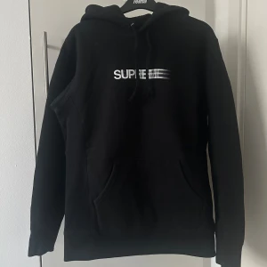 Supreme motion logo  svart hoodie, storlek MEDIUM - Säljer en svart hoodie från Supreme med vit logga framtill. Klassisk modell med huva och känguruficka. Perfekt för dig som gillar streetwear och vill ha något stilrent men ändå med tydlig branding.