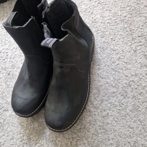 Svarta boots från Kavat - Säljer ett par svarta boots från Kavat i skinn med elastiska paneler på sidorna och grov sula. Skorna har rund tå och kontrastsöm runt sulan. Perfekta för höst och vinter. Köptes för 1000kr men säljer nu för 800 eftersom att skorna ALDRIG använts 