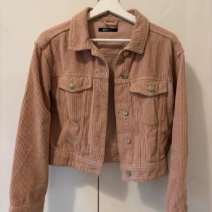 Rosa manchesterjacka från Gina Tricot - Säljer en ljusrosa croppad manchesterjacka från Gina Tricot. Jackan har långa ärmar, knappar framtill och två bröstfickor med lock. Perfekt för vår och höst