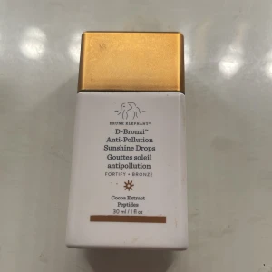 bronzing drops - D-Bronzi Anti-Pollution Sunshine Drops från Drunk Elephant ger huden en bronzig glow och skyddar mot föroreningar. Innehåller kakaoextrakt och peptider. Kommer i en smidig flaska med guldigt lock, 30 ml.