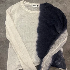 Svartvit stickad tröja från Weekday - Säljer en tunn stickad tröja från Weekday i storlek M. Tröjan har ett coolt svart och vitt färgblocksmönster och är långärmad med rund halsringning. Perfekt för lager-på-lager och en avslappnad stil.