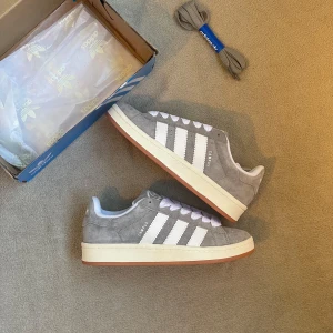 Adidas Campus grå - Adidas campus 00s i grå. Passar storlek 39. En av dem trendigaste skorna till sommaren. Skorna är i ny skick. Nypris 1499 vårt pris 749kr📍  Hör gärna av er vid frågor!