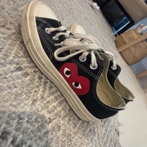 Converse x Comme des Garçons Play sneakers - Svarta Converse x Comme des Garçons Play sneakers med den ikoniska röda hjärtloggan på sidan. Skorna har vita snören, vit tå och sula samt klassisk låg modell. Använda några gånger 