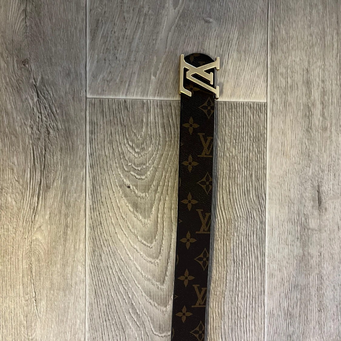 Brunt bälte med monogram och guldfärgat spänne