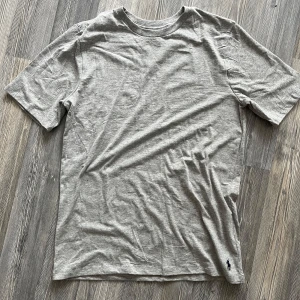 Grå t-shirt från Polo Ralph Lauren - Säljer en enkel och stilren grå t-shirt från Polo Ralph Lauren. T-shirten har korta ärmar, rund halsringning och en liten broderad logga nertill. Aldrig använd då den var för stor. Köp alla tre för 450:-🫰