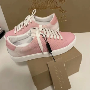 Burberry sneakers i rosa och vitt skinn - Säljer ett par snygga Burberry sneakers i rosa och vitt. Kommer med originalkartong och tagg. Använda en gång innan jag insåg att dom va för små så i nyskick💗