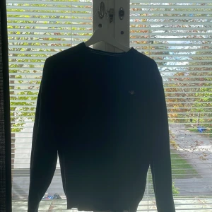 Mörkblå tröja från GANT - Säljer en klassisk mörkblå tröja från GANT med rund halsringning och diskret logga på bröstet. Tröjan har långa ärmar och ribbade muddar vid hals, ärmslut och nederkant. I bra skick, köpt för 1400kr💙