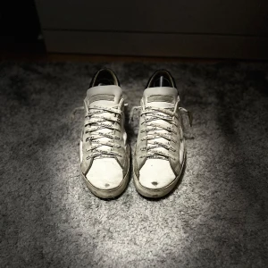 Phillipe Modell - Säljer ett par Phillipe Model med grå mockadetaljer och svart häl. Skorna har snörning och platt sula, samt rund tå. Perfekta för dig som gillar en stilren och avslappnad look till sommarn.