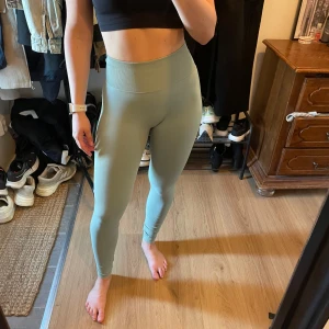 Ljusgröna seamless leggings från ICANIWILL - Säljer ett par ljusgröna seamless leggings från ICANIWILL. De är högmidjade och har en tight passform med ribbade detaljer. Perfekta för träning eller chill dagar. Snygg och stilren design med diskret logga på höften. Passar mig som är en xs/s. Mycket sparsamt använda.
