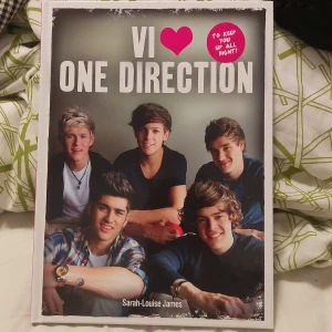 Vi ♥ One Direction - En bok om det populära pojkbandet One Direction. Omslaget har en bild på bandmedlemmarna och titeln i stora vita bokstäver. Boken är på svenska och innehåller fakta, bilder och berättelser om Niall, Zayn, Liam, Harry och Louis.