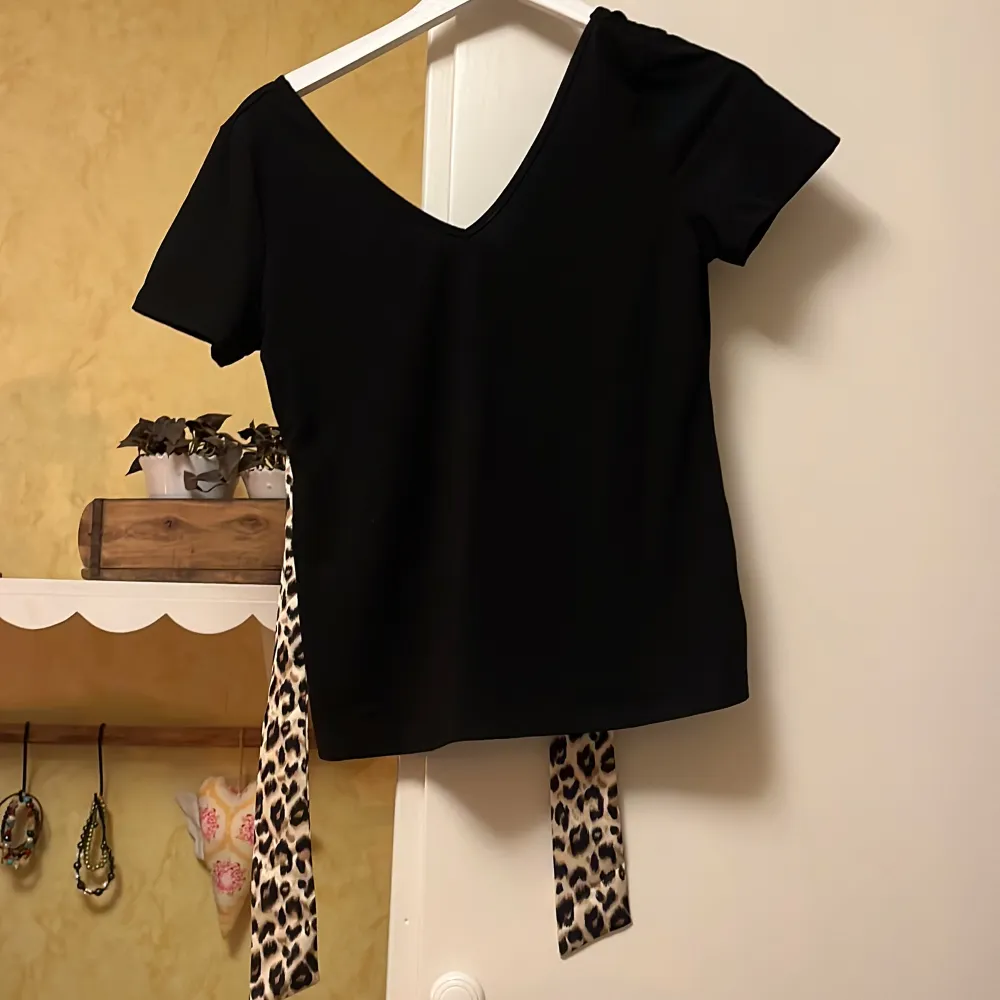 V-ringad svart tröja med leopard snörining ryggen . T-shirts.