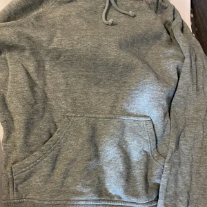 Luvtröja  - Tjocktröja med luva ifrån bik bok, i mycket bra skick då den endast använt ett par gånger, färgen är grå/grön 