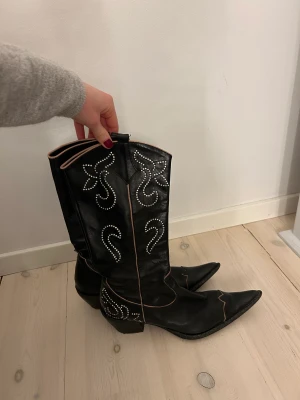 Svarta cowboystövlar med strass - Svarta cowboystövlar med rosa detaljer och silvrig strass 
