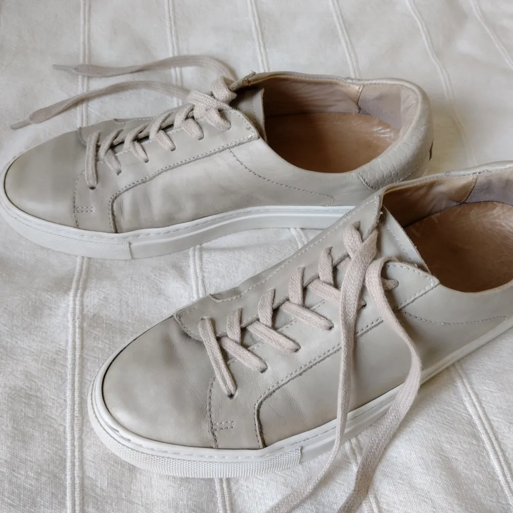 Beige sneakers från Rizzo. Mjuka och sköna med skinn både in- och utvändigt. Sparsamt använda - yttersulan lite sliten baktill och lädret lite flammigt/missfärgat (syns mer på bilderna med blixt). Går kanske fixa med läderbalsam. Storlek 40.. Skor.