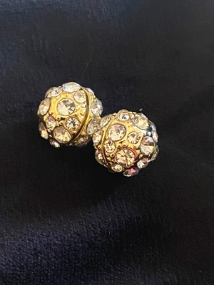 Örhängen magnetiska - Små kulformade örhängen som sitter fast med starka magneter   Guldfärgade med gnistrande rhinestones 