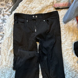 Randiga Bootcut kostymbyxor - As coola kostymbyxor med snygga detaljer. Dragkedjor längst ner vid benen så man kan göra de mer bootcut eller mindre om man vill. Väldigt långa i benen, skulle säga 34 i längd. Storlek M!