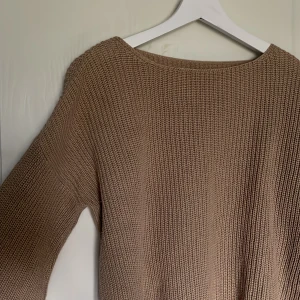 Brun stickad tröja  - Brun stickad tröja med båturringning och utsvängda ärmar. Från NA-KD i toppenskick
