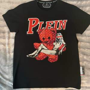 Hej, Säljer min philipp plein T-shirt teddy edition som är i sprillans nytt skick, alla ”diamanter” är på sin plats inte en enda har lossnat. Köpt på NK, Väldigt sällsynt T-shirt, såldes som limited edition.  -Möts upp -Köparen står för frakt