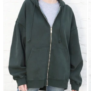 Mörkgrön Brandy Melville Christy hoodie - Säljer min mörkgröna Christy hoodie från Brandy Melville då den inte kommer till användning 💘 Eftersom att den ska sitta oversize passar de många storlekar! Skriv för flera frågor eller bilder!! Kan mötas upp eller frakta!