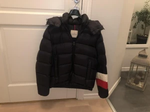 Moncler jacka. - Moncler Willm, varm och go vinterjacka från Moncler i Size 3 vilket motsvarar Medium. Jackan är mörkblå och har det klassiska tri color mönstret på ena armen. Jackan är i fint skick, 8,5/10 och har ingen skavanker.  Nypris på denna modell var runt 12500kr