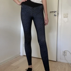 High waisted träningstights från Drop of Mindfullness - Träningstights från Drop of Mindfullness i storlek S med zebramönster. Använd fåtal gånger därav nyskick. Säljer pga att de inte kommer till användning då de är för korta. Beninnesöm 76cm