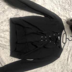 En svart tröja med lite korsett detaljer, söt och lite kortare. Storlek xs