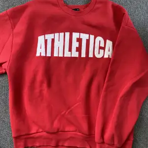 Röd sweatshirt från Gina Tricot med vitt tryck ”Athletic”. Stl M.