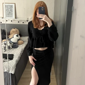 Midi kjol - Svart midi kjol med slits ifrån Gina Tricot, passar perfekt till färgglada festtoppar men är även fin på hösten till en stickad tjocktröja