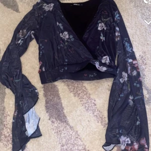 Croppad topp - Croppad topp från Ginatricot i storlek M. Använd 1 gång, ser ut som ny. Väldigt mjukt och tunt material. Armarna är fladdriga.