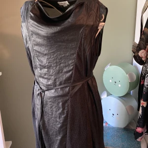 Klänning till fest/ uppklädd vardag - Mångfacetterad klänning som går att styla på många olika sätt. Tyvärr blivit för liten för mig, använd sparsamt innan dess. Storlek L men tack vare midjeband passar den bra också till en M. Köpt för många år sen.