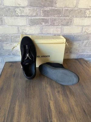 Arigato Skor  - Säljer ett par svarta Arigatod med zip. Använda ändas en gång, är i mycket fint skick. Ställ gärna frågor om ni har funderingar! 