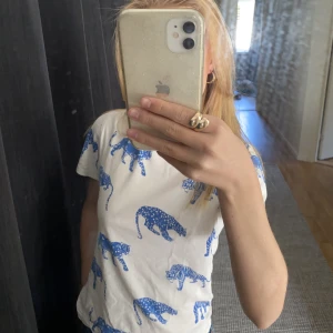 T-shirt  - En vit t-shirt från H&M med olika blåa kattdjur som tryck. Bra skick men för liten för mig🫶🏼
