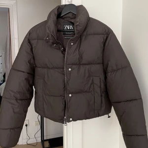 Pufferjacka Zara - En brun pufferjacka från Zara. Den är matt och har en fin askig/kall brun nyans. Den är även vattentät! Varm och gosig