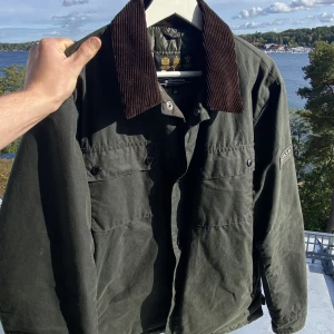 Barbour International jacka - Säljer min Barbour International jacka i storlek M i fint skick i en mörkare olivgrön. Jackan är vaxad och tål regn och vind. Tags och kvitto finns. Kan mötas upp i Sthlm eller frakta. Vid frågor kom DM😆