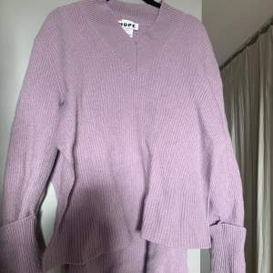 En pastellila ulltröja från HOPE med slitsar längst med sidorna av tröjan. Köpt för ett tag sedan men enbart använd 2 gånger. Storlek 40 men pga slitsarna passar den de flesta.