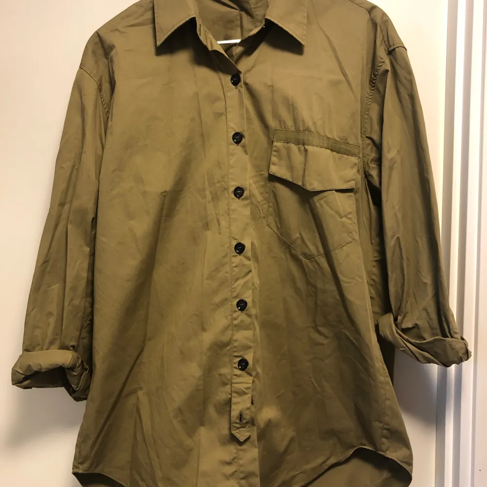 Cool långskjorta i militärgrönt från  Zara SRPLS!  Så fina detaljer med knappar och remmar (kolla knapparna bak på ryggen!) Ingen anmärkning. Material: bomull Storlek: L. . Skjortor.