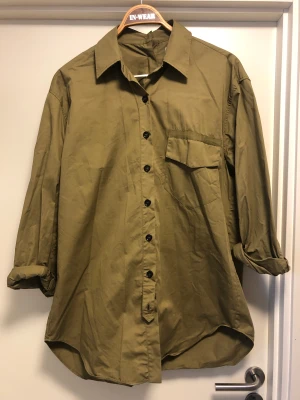 Snygg militärskjorta från Zara!  - Cool långskjorta i militärgrönt från  Zara SRPLS!  Så fina detaljer med knappar och remmar (kolla knapparna bak på ryggen!) Ingen anmärkning. Material: bomull Storlek: L. 
