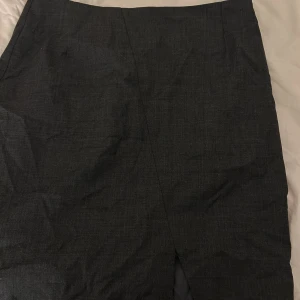 Kjol  - Säljer denna fina korta kjol från STOCKH LM🩶 •Aldrig använd. •Mörk grå  •Slits där nere och dragkedja på sidan!