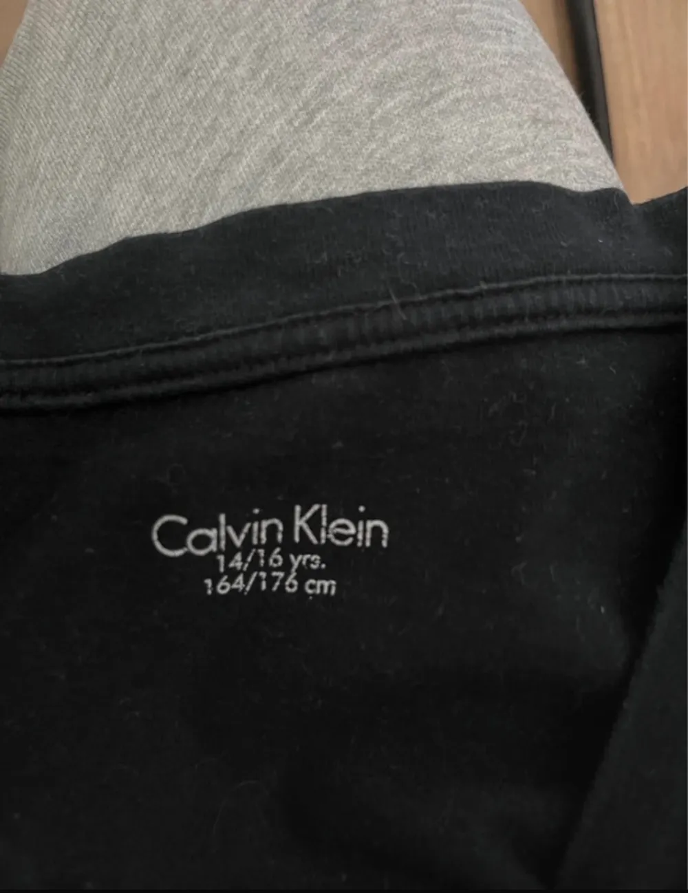 Svart Calvin Klein t-shirt med diskret tryck. Bredd axlar 42 cm. Bredd under ärmarna 46 cm. Längd 65 cm. OBS‼️ storlek 164/176 men använd som XS. T-shirts.