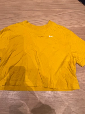 Kroppad t-shirt - Säljer denna fina gula kroppade t-shirt från Nike. Kommer inte till användning för mig. Köparen står för frakten💕