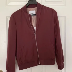 Vin röd bomber jacka - Super ball vinröd bomber jacka i storlek S köpt på Plick för 350 kr  använd en gång, ny utan prislapp. Den har en liten fläck men det är inget som syns  kom privat för fler bilder❤️