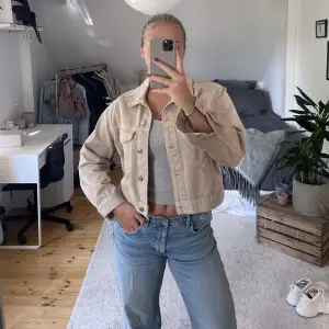 Beige jeansjacka i kort modell. Använd endast en gång.