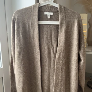 Lång kofta H&M - Längre kosta från H&M som knappt kommit till användning 