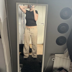 Byxor - Moderna byxor i tyg, sitter fint på. Saknas en knapp vid ”gylfen” men går att sy på egen om man vill det. Lågmidjade