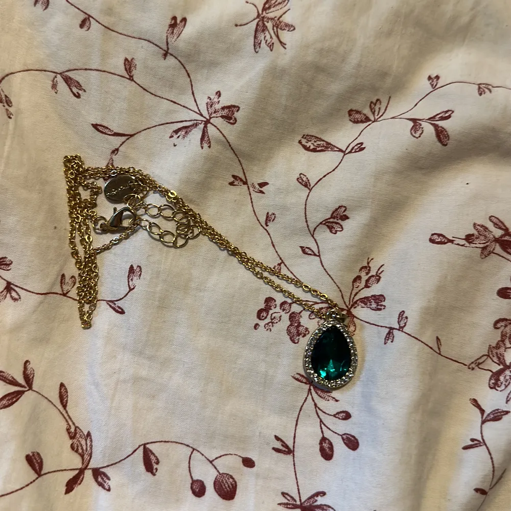Säljer detta fina halsband men ett hänge i form av en smaragd liknande i mitten och små diamanter runt. Accessoarer.