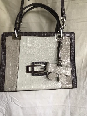 Guess väska  - Stabil, många fack. Använd = märken under, i övrigt fin och ren.  Ca 30x35 cm