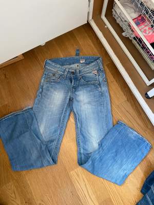 Ljusblåa low waist bootcut jeans som är från replay