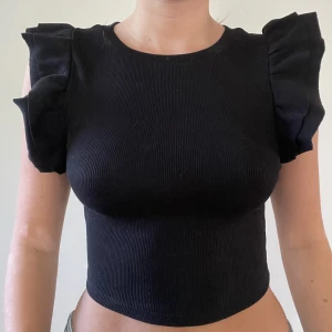 Topp med volanger - Säljer dessa toppar med volanger på ärmarna från Zara. Har två svarta, en i storlek S och en i M. Den vita är i storlek S. Använda ett fåtal gånger och är i mycket bra skick! Om fler är intresserade blir det budgivning. *frakt tillkommer*