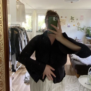 Randig figursydd skjorta M  - Svart skjorta med vita ränder - figursydd. Skitsnygg, lite ”skrynkligt sydd” runt bysten, vida öppna armar som går precis över handen  Sitter lite tight på mig därav säljer jag den. Köpt på humana för 250 